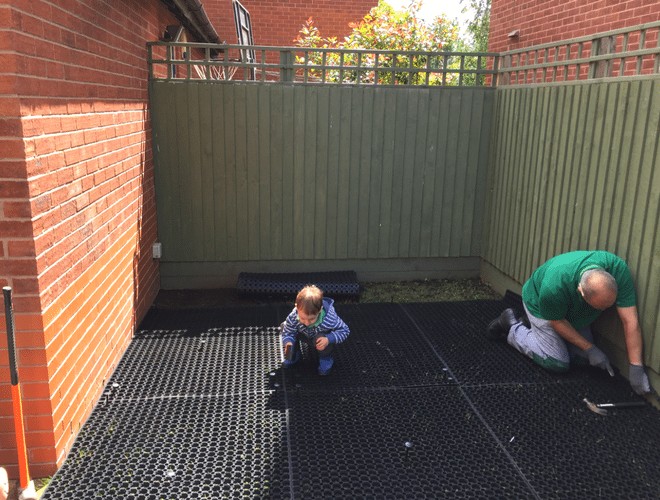 Rubber Grass Mats Being Installed Under Playhouse